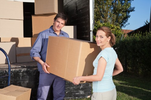 Local movers carrying boxes through a flat building in Hendon